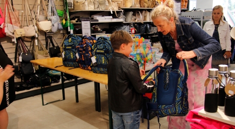 Coop Hiiumaa juht Kaja Antons kingib kooliteed alustavale lapsele ranitsa. Foto: Coop Hiiumaa